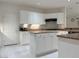 Kitchen featuring white cabinets, an island, stone countertops and stainless appliances at 2451 Tour Edition Dr, Henderson, NV 89074