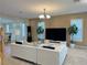 Modern living room with a white sectional sofa, 3D wall design, and large windows at 2451 Tour Edition Dr, Henderson, NV 89074