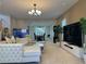 Spacious living room with a white sectional sofa, TV, and view into the dining room at 2451 Tour Edition Dr, Henderson, NV 89074