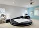 Bright bedroom featuring a round bed, a ceiling fan, a workstation and ample closet space at 2451 Tour Edition Dr, Henderson, NV 89074