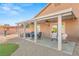Inviting covered patio with ceiling fans, dining set, hot tub and adjacent play area in the backyard at 2720 Mickey Mantle Ct, Las Vegas, NV 89108