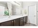 Bright bathroom featuring double sinks, dark cabinetry and a large mirror at 2720 Mickey Mantle Ct, Las Vegas, NV 89108
