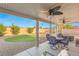 Charming covered patio with ceiling fans, outdoor seating, and views of the backyard play area at 2720 Mickey Mantle Ct, Las Vegas, NV 89108