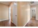 Hallway with wood laminate flooring with white doors and peach walls at 2809 Mason Ave, Las Vegas, NV 89102