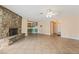Open living room with a stone fireplace, tile flooring, and ceiling fan at 2809 Mason Ave, Las Vegas, NV 89102
