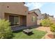 Inviting backyard with a fire pit sitting on artificial turf, complemented by desert landscaping and a covered patio at 2964 Gunnery Forge St, Las Vegas, NV 89156
