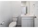 This bathroom has a sink, toilet, and mirror with white cabinets and floors at 2964 Gunnery Forge St, Las Vegas, NV 89156