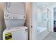 Bathroom featuring a tub with glass shower doors next to a stackable washer and dryer at 2964 Gunnery Forge St, Las Vegas, NV 89156