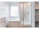 Bright bathroom featuring a tub, and a glass enclosed shower with a seat at 2964 Gunnery Forge St, Las Vegas, NV 89156