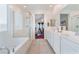 Bright bathroom featuring a double vanity, a tub, and a glass-enclosed shower, offering a clean and modern design at 2964 Gunnery Forge St, Las Vegas, NV 89156