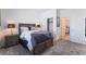 Neutral bedroom with a wooden bed frame, soft gray carpet, and a view into another bedroom at 2964 Gunnery Forge St, Las Vegas, NV 89156