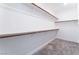 Spacious walk-in closet with wooden closet rods and gray carpet at 2964 Gunnery Forge St, Las Vegas, NV 89156