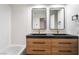 Bathroom vanity featuring double sinks, wood cabinetry, and modern mirrors at 3260 Longford Way, Las Vegas, NV 89121