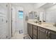 Bright bathroom featuring a double vanity, neutral cabinets, and framed mirrors at 329 Brockbank Pl, Henderson, NV 89011