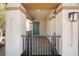 A covered front porch with a gated entry, features stone pillars and walkway to a teal entry door at 329 Brockbank Pl, Henderson, NV 89011