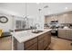 Open kitchen with an island, stainless steel appliances, and tile backsplash at 329 Brockbank Pl, Henderson, NV 89011