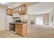 Bright kitchen with tile floors, wood cabinets, granite counters, and view into the living room at 3318 N Decatur Blvd # 1061, Las Vegas, NV 89130