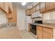 Bright kitchen featuring tile floors, wood cabinets, granite counters, and modern appliances at 3318 N Decatur Blvd # 1061, Las Vegas, NV 89130