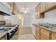 Bright kitchen with tile floors, wood cabinets, granite counters, and view into the living room at 3318 N Decatur Blvd # 1061, Las Vegas, NV 89130