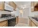 Bright kitchen with tile floors, wood cabinets, granite counters, and view into the living room at 3318 N Decatur Blvd # 1061, Las Vegas, NV 89130
