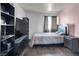 Neutral bedroom with a hardwood floor, a modern entertainment center, and curtains over the window at 3389 Commendation Dr, Las Vegas, NV 89117