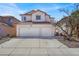 Inviting two-story home with a tile roof, a two-car garage, and a wide driveway under a bright blue sky at 3389 Commendation Dr, Las Vegas, NV 89117