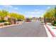 Gated entrance to the community, surrounded by lush landscaping and flowering trees at 3518 Herodain Ave, Las Vegas, NV 89106