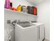 Neat laundry room with white washer and dryer, and a shelf for storage of supplies at 3518 Herodain Ave, Las Vegas, NV 89106
