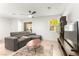 Open-concept living room featuring a sectional sofa, neutral tile flooring and an area rug at 3518 Herodain Ave, Las Vegas, NV 89106