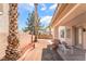 Charming backyard featuring palm trees, a covered patio with furniture, and beautiful landscaping at 3786 Port Ritchey St, Las Vegas, NV 89147