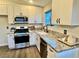 Updated kitchen with granite countertops, stainless steel appliances, and white cabinets, offering a modern aesthetic at 407 Tiger Lily Way, Henderson, NV 89015