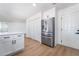 An open kitchen features a stainless refrigerator, white cabinets and wood look flooring at 4442 Bennett Dr, Las Vegas, NV 89121