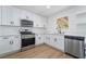 Bright kitchen featuring white cabinets, stainless steel appliances and wood floors at 4442 Bennett Dr, Las Vegas, NV 89121
