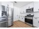 Modern kitchen featuring white cabinets, stainless steel appliances and wood floors at 4442 Bennett Dr, Las Vegas, NV 89121