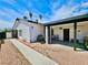 Exterior view of a white home with a covered patio, xeriscaping, and a walkway at 4681 Via San Rafael, Las Vegas, NV 89103