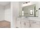 Bathroom vanity with white cabinets, a quartz countertop, a sink, and a large mirror reflecting the bath at 5725 El Royale Ct, Las Vegas, NV 89149
