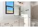 A bright bathroom showcasing a white vanity with modern fixtures, a rectangular mirror, and a view of the bathtub at 5725 El Royale Ct, Las Vegas, NV 89149