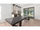 Open-concept dining area featuring hardwood floors, natural light, and a long modern wooden table at 5725 El Royale Ct, Las Vegas, NV 89149