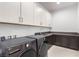 Bright laundry room with modern washer and dryer and clean white cabinets at 5725 El Royale Ct, Las Vegas, NV 89149