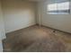 A compact bedroom features a window and neutral walls and carpet at 613 Buchanan Ave, Henderson, NV 89015