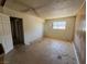 This bedroom has neutral walls, a window for natural light, and awaits new flooring and remodeling at 613 Buchanan Ave, Henderson, NV 89015