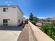 View of home's side yard and backyard with a concrete patio and brick wall at 7748 Catalina Harbor St, Las Vegas, NV 89131