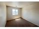 A bright bedroom with neutral carpet, walls, and a window allowing natural light at 7748 Catalina Harbor St, Las Vegas, NV 89131