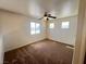Spacious bedroom with carpet, ceiling fan, and ample natural light from three windows at 7748 Catalina Harbor St, Las Vegas, NV 89131
