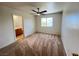 Cozy bedroom with neutral carpet, ceiling fan, and ensuite bathroom access at 7748 Catalina Harbor St, Las Vegas, NV 89131