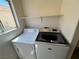 Bright laundry area featuring modern washer and dryer units, plus a convenient storage shelf at 7748 Catalina Harbor St, Las Vegas, NV 89131