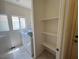 Functional laundry room with modern appliances, a window for natural light, and built-in shelving at 7748 Catalina Harbor St, Las Vegas, NV 89131
