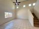 Bright living room featuring a ceiling fan, tall ceilings, tile floors and staircase at 7748 Catalina Harbor St, Las Vegas, NV 89131