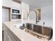 A close-up of a modern stainless steel sink and faucet with white countertop and cabinets at 785 Black Palace St, Henderson, NV 89011