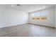 Open living room showcasing wood-look tile flooring and natural light coming in from three large windows at 785 Black Palace St, Henderson, NV 89011